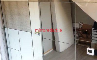 A wall of varying sizes of mirror with cutouts for electrical controls and sockets. The mix of silver and gentle antique mirror created a unique and stunning feature wall.